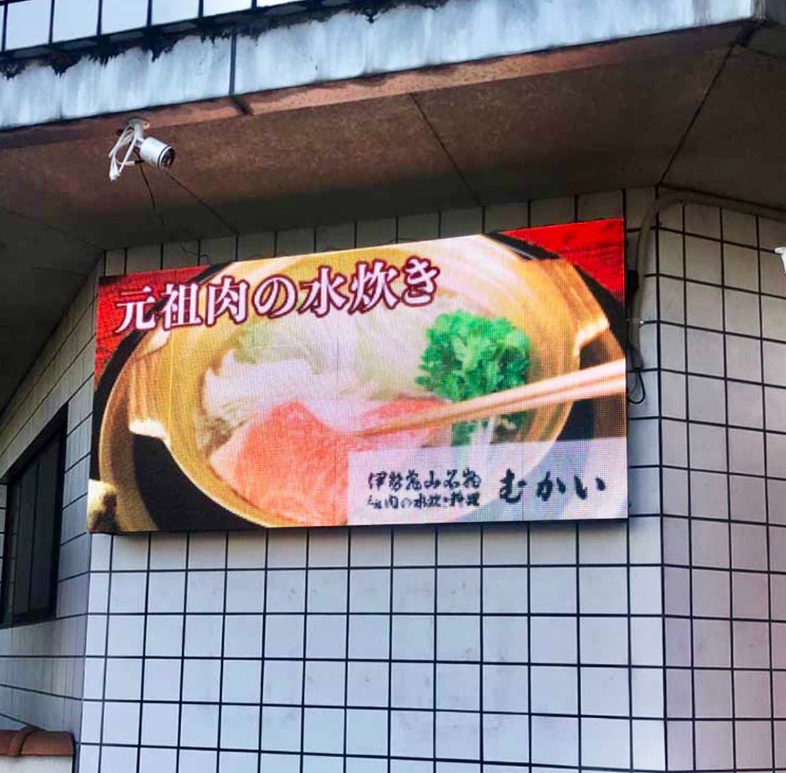 むかいの外壁に設置された横長LEDビジョン（元祖肉の水炊き表示）