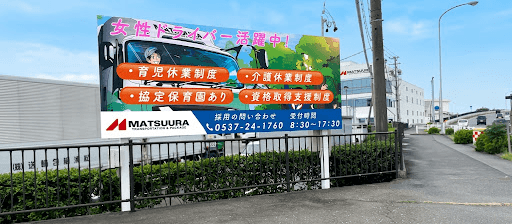 MATSUURAの倉庫前に設置された大型LEDビジョン全面（女性ドライバー求人情報表示）